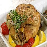 Helstekt fylt kylling med urter og sitron, servert på en seng av linser og grønnsaker