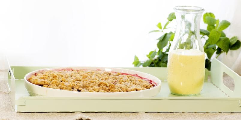 Smuldrepai med pærer og bringebær, servert med vaniljesaus