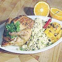 Helstekt fylt kylling servert med appelsin og couscous